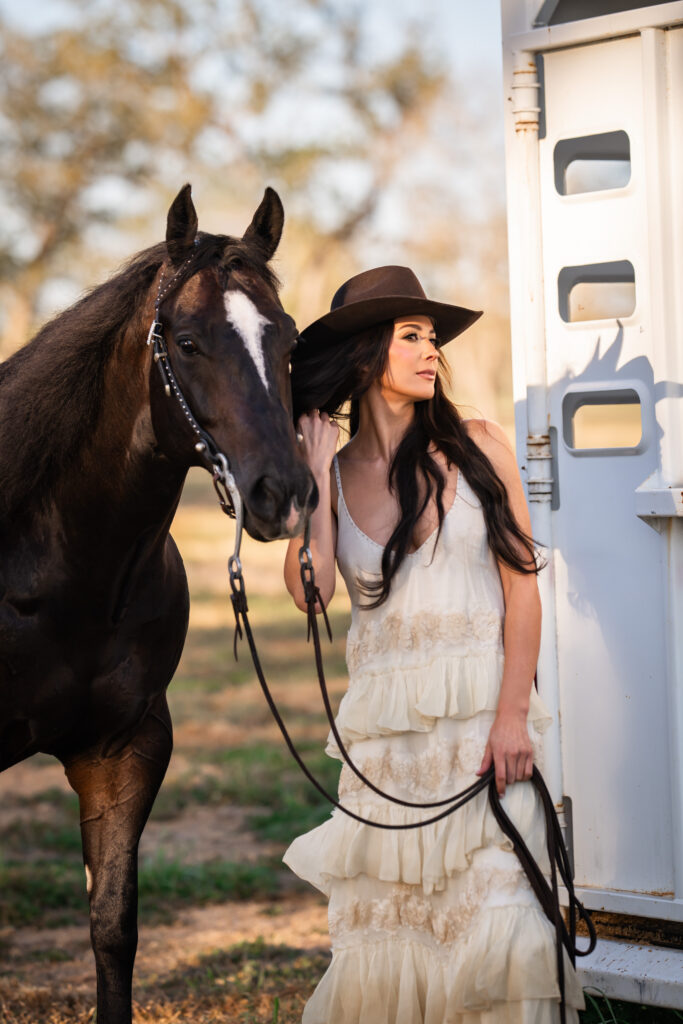 woman standing next to her horse and horse trailer