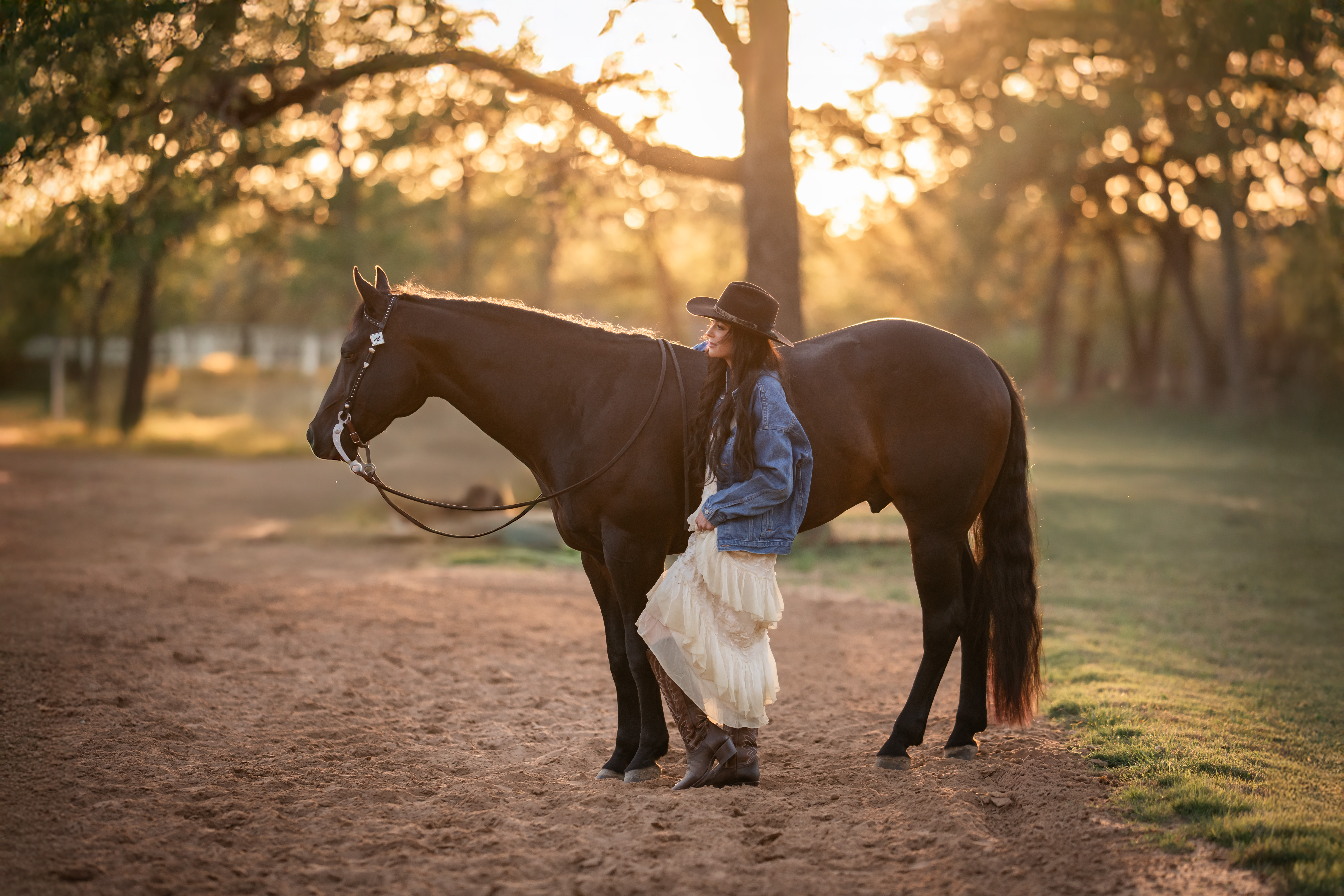 A woman standing next to her horse in a Houston arena