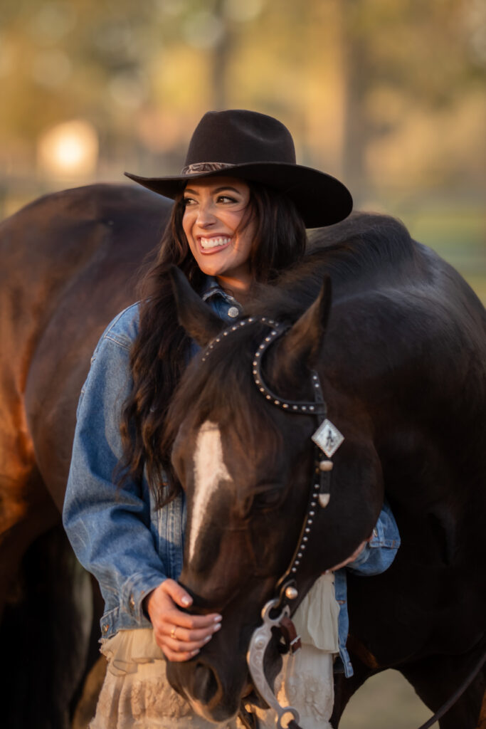 Woman standing next to her horse smiling